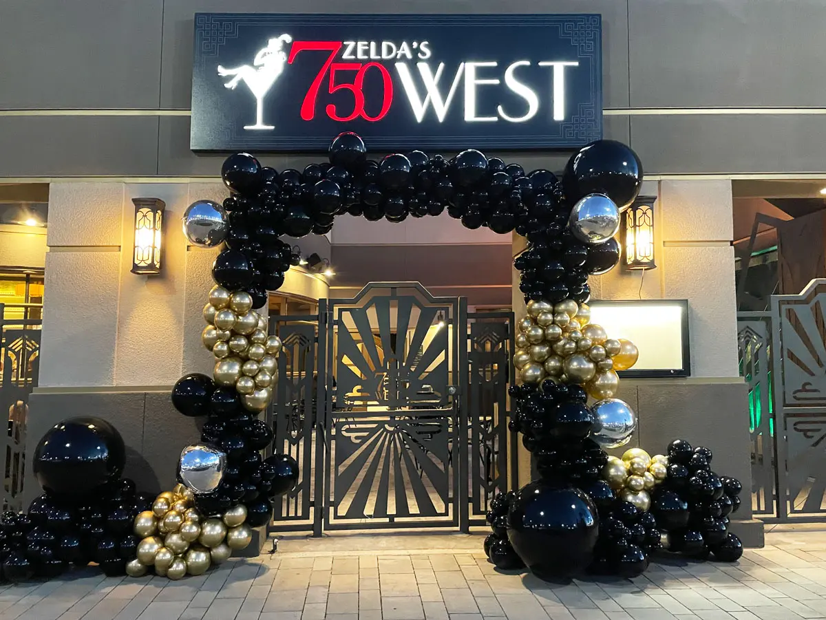 The front gate of Zelda's 750 West decorated with black and gold balloons.